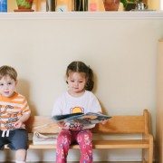 Little girl reading books and boy looking to a camera