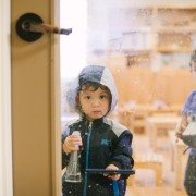 Kid wearing coat cleaning crystal door
