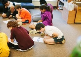 Kids reading paper in the floor